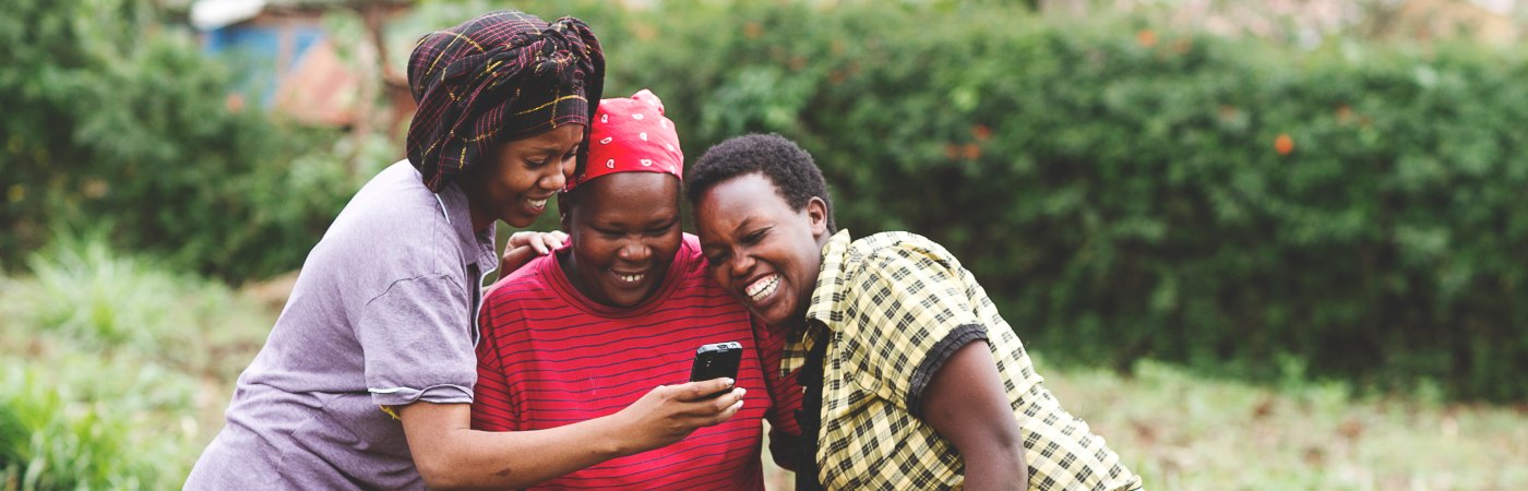 group of women in Kenya looking at mobile phone