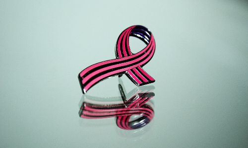A pin that represents breast cancer awareness.