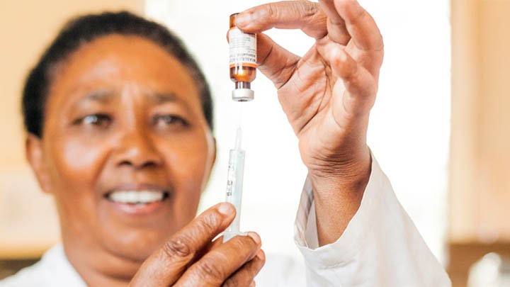 African nurse preparing to administer vaccine.