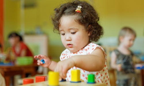 Young girl playing with toys at school