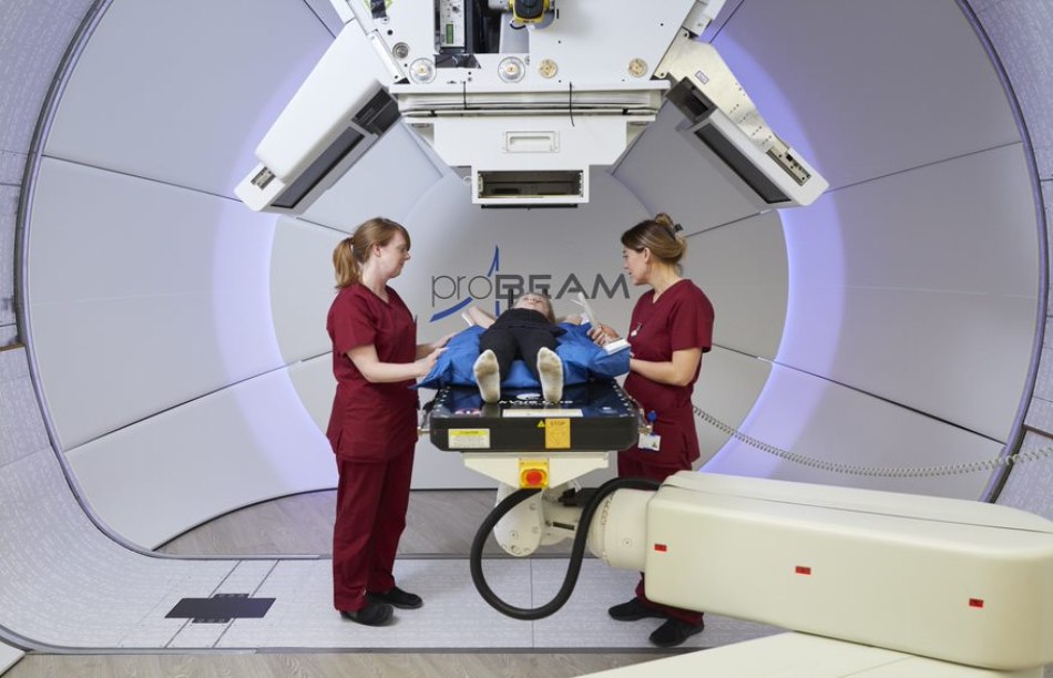 Proton Beam therapy gantry in The Christie Hospital with child patient and nurses attending.