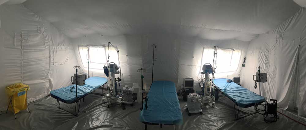Hospital beds and medical equipment inside a field hospital.
