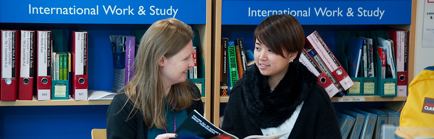 Student with support staff in library
