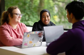 Three students working at laptops.