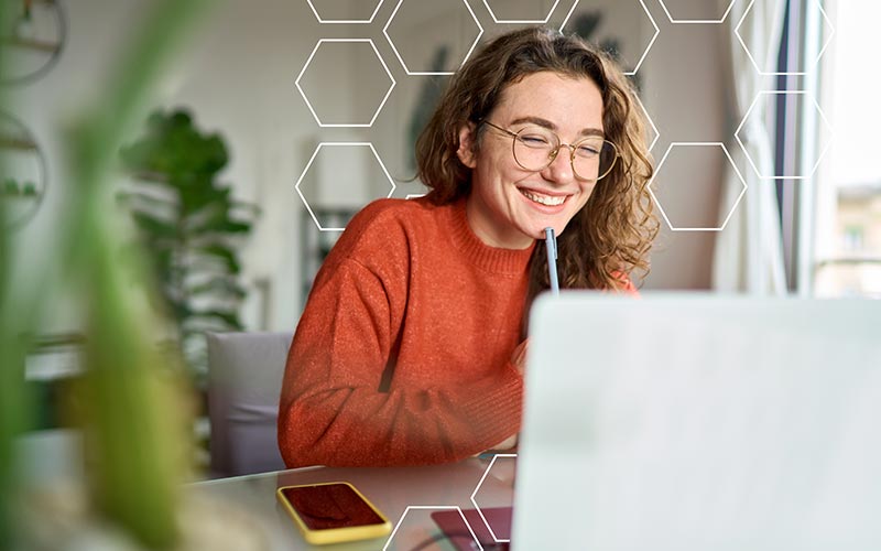 Woman smiling while looking at her laptop