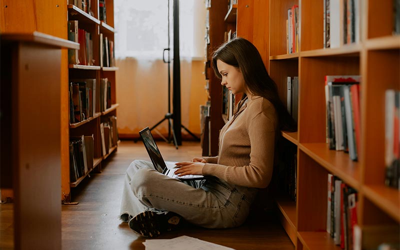 A woman on a laptop in a library