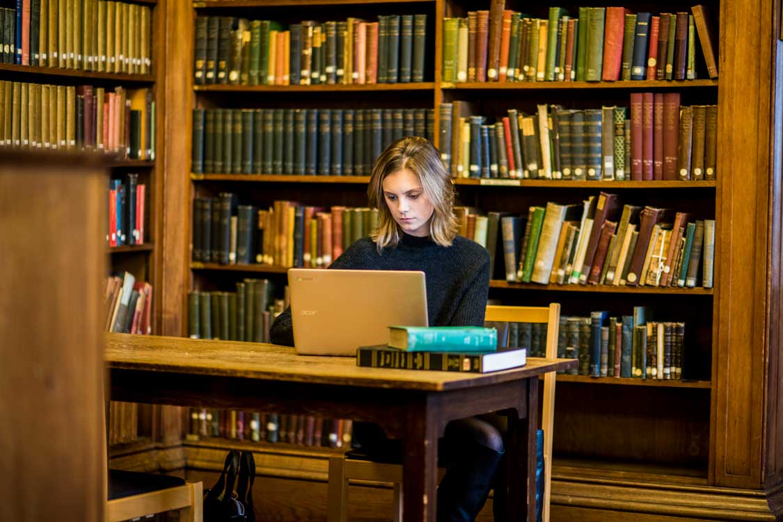 A student on a laptop in the library
