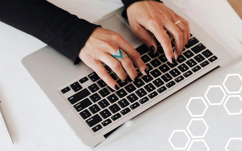 A person typing on a laptop keyboard