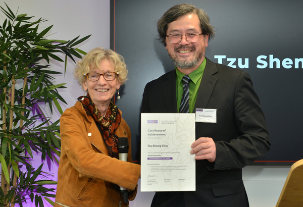 a man and woman smiling holding a certificate