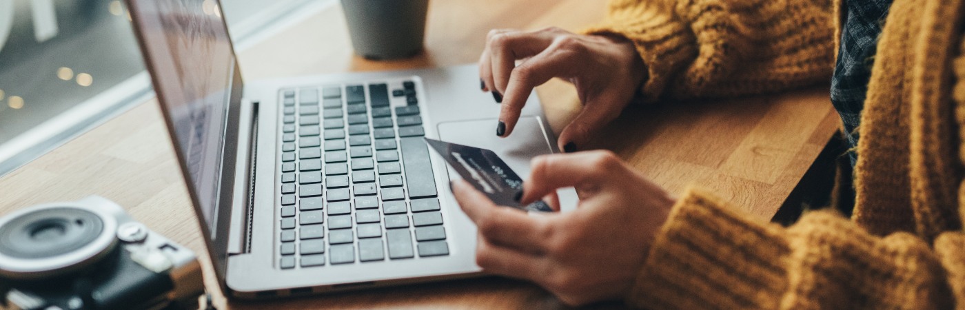 Woman paying for something with her card on her laptop.