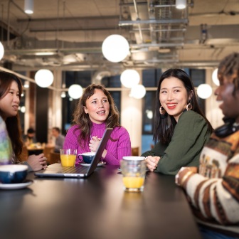 Students sat at tables outside a coffee shop