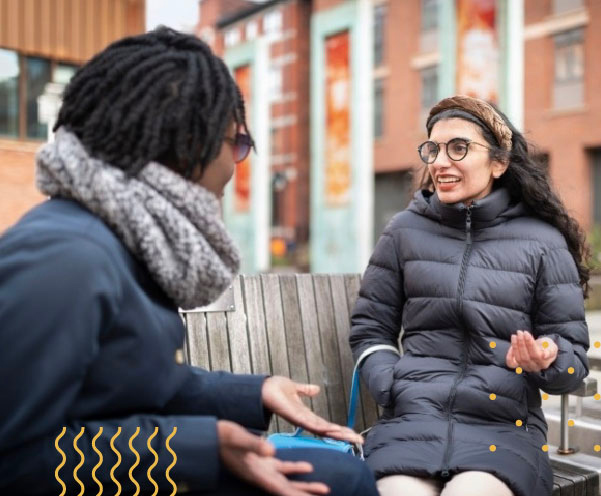 Two students chatting on a bench