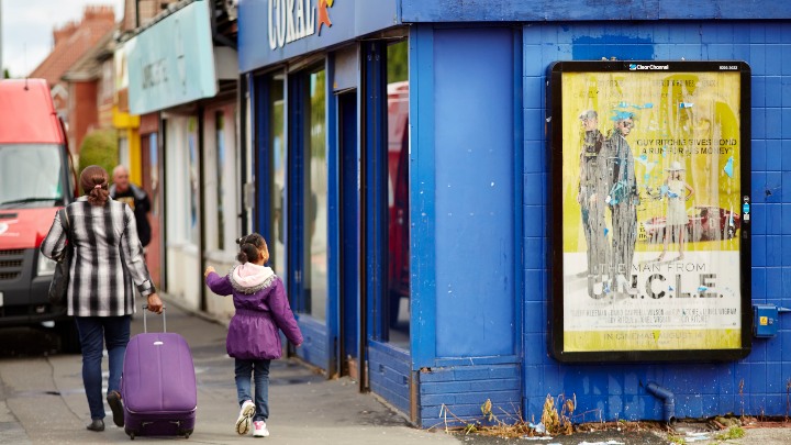 Woman and child walking past a betting shop.
