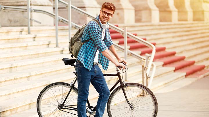 Male student on placement riding a bicycle