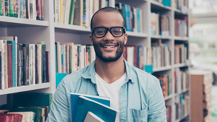 Male student smiling in the library