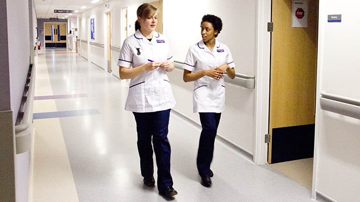 Midwifery students walking down a hospital corridor.