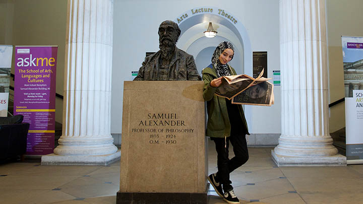 Student reading paper in Samuel Alexander building