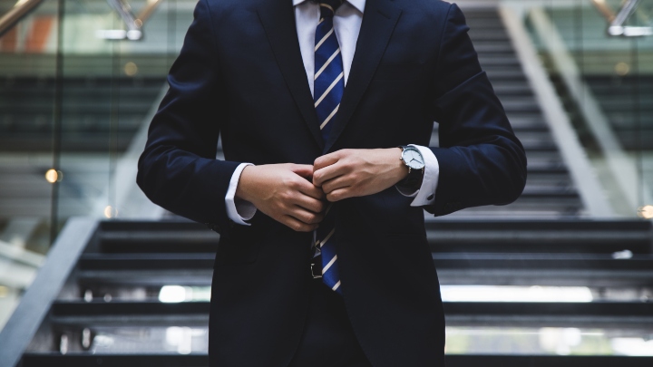 Male in suit stood at bottom of stairs