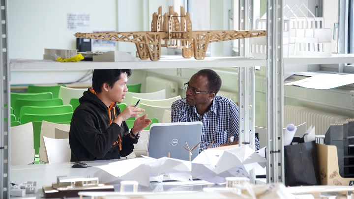 Student and academic chatting in workshop