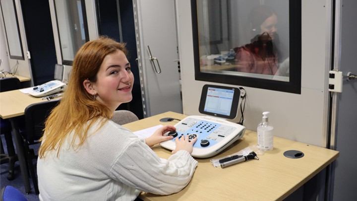 An audiology student using equipment.