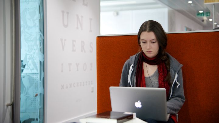 Female student sat down typing on laptop