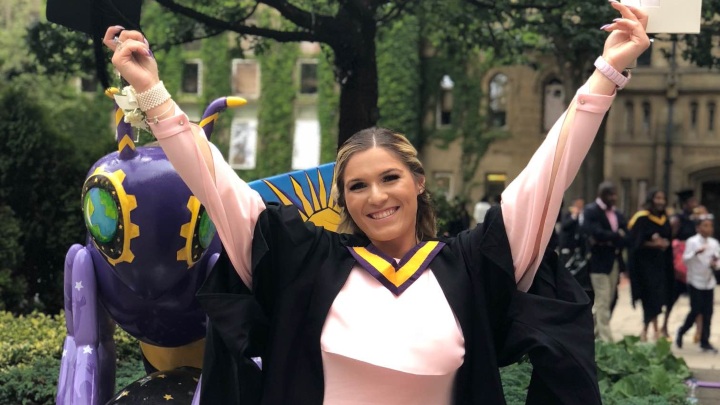 Student in graduation gown holding certificate