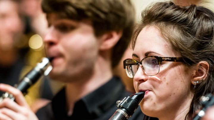 Closeup of two people playing instruments