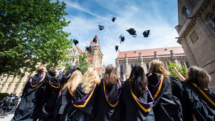 Students at graduation throwing hats into the air