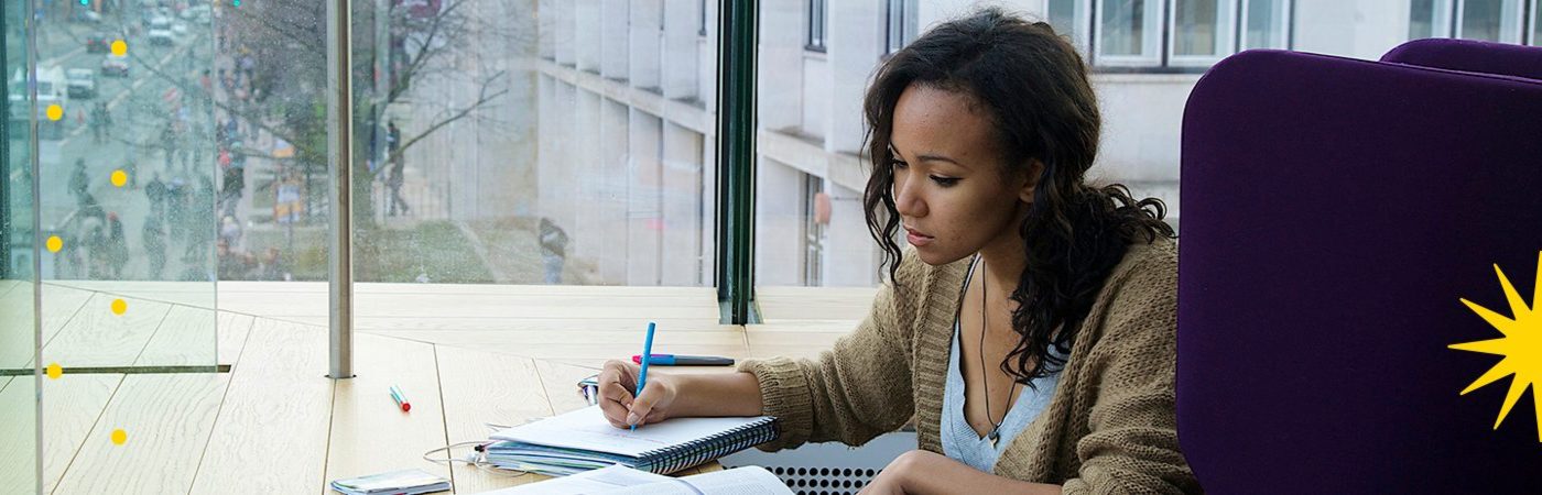 Girl sat by window writing notes