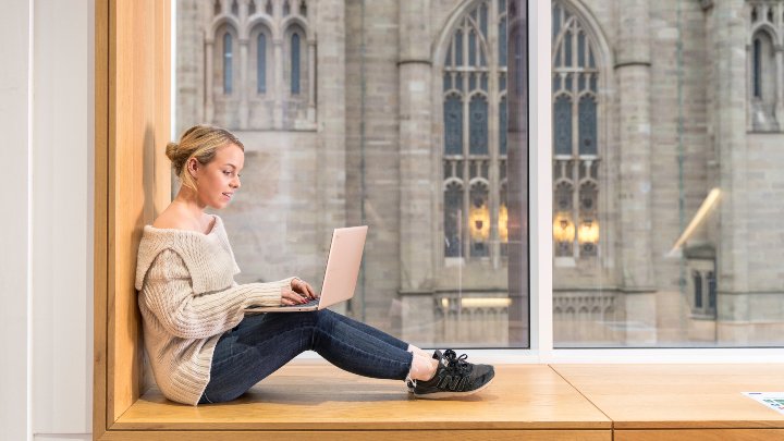 A female student working at a laptop