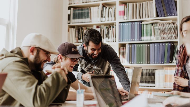 A group of students laughing in a library