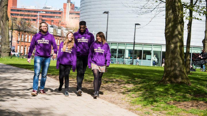 A group of students in purple jumpers walking down Oxford Road