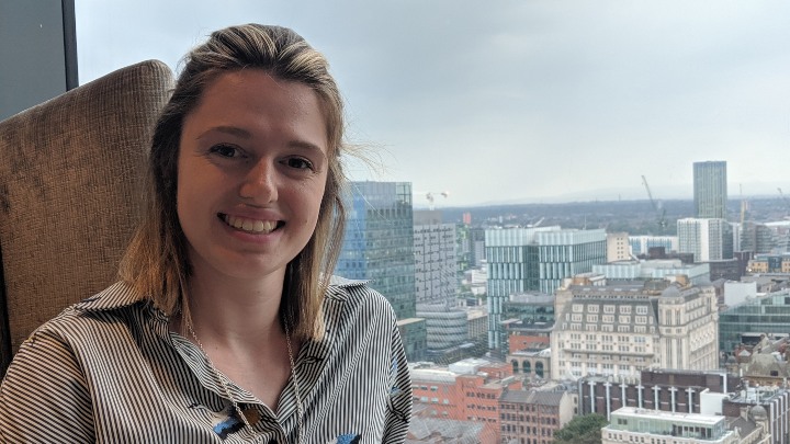 Eleanor in front of a window, with the city in the background