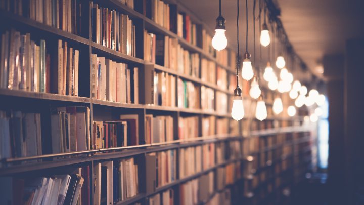 Shelves of books with hanging lamps