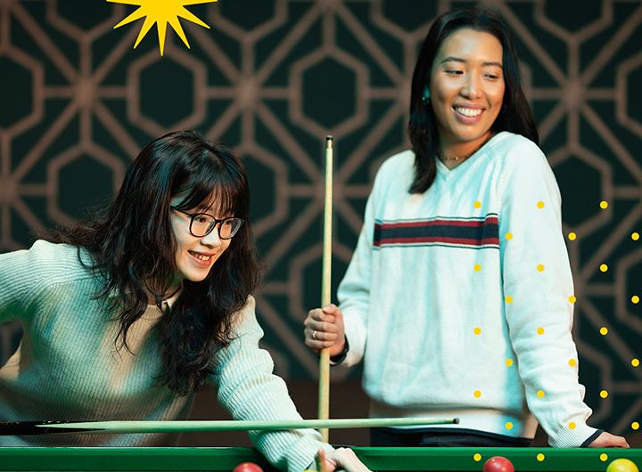 Two female students playing pool