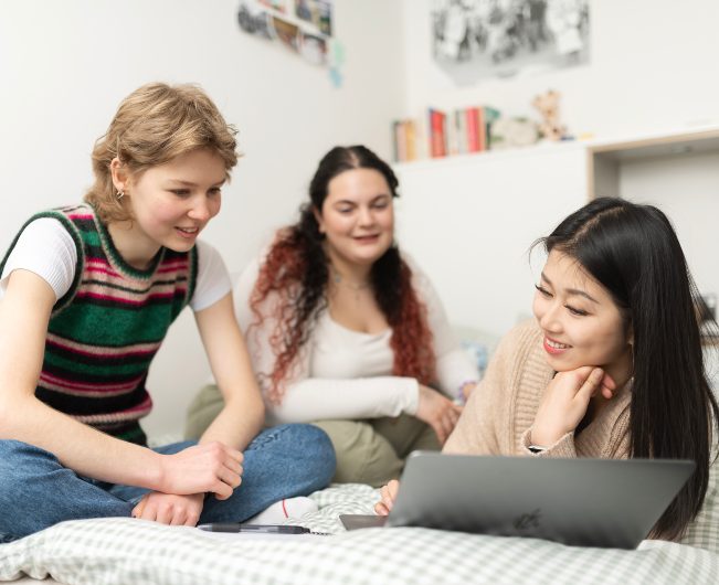Group of students looking at a laptop