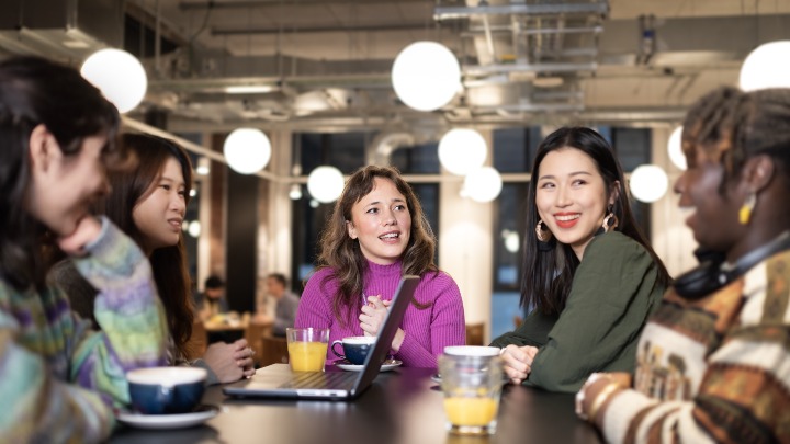 Group of students chatting around a table 
