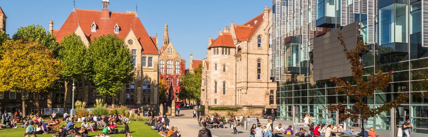 The view outside the University's Alan Gilbert Learning Commons on a sunny day with students sat around.