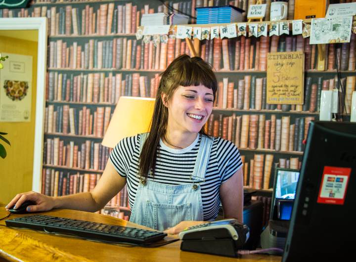 Smiling woman in dungarees using computer