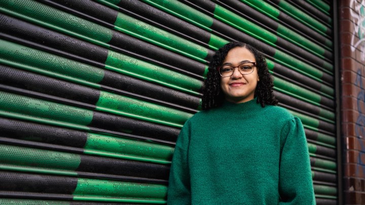 Smiling student standing by the canal